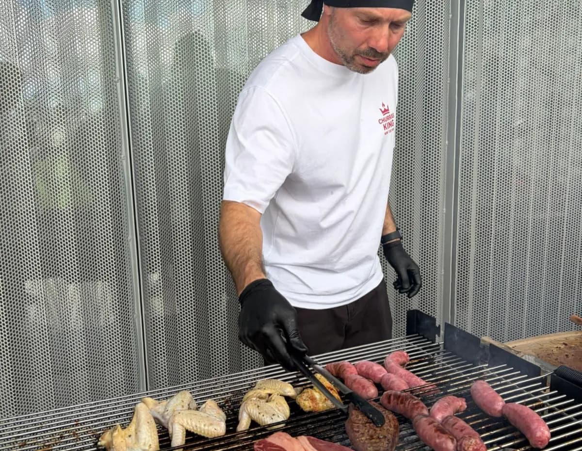 Churrasqueiro do ChurrasKing a virar as carnes na grelha