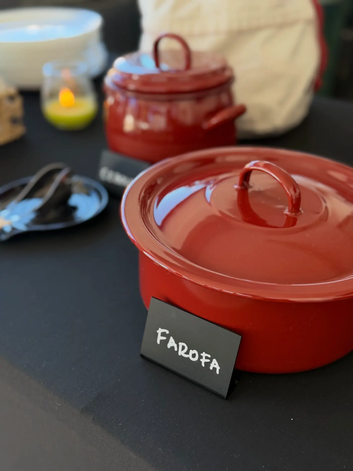 Panela vermelha de farofa na mesa do buffet
